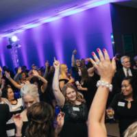Guests dancing, throwing their hands in the air in the Laker Lounge.